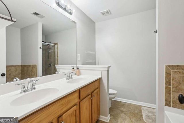 bathroom featuring visible vents, toilet, double vanity, a stall shower, and a sink