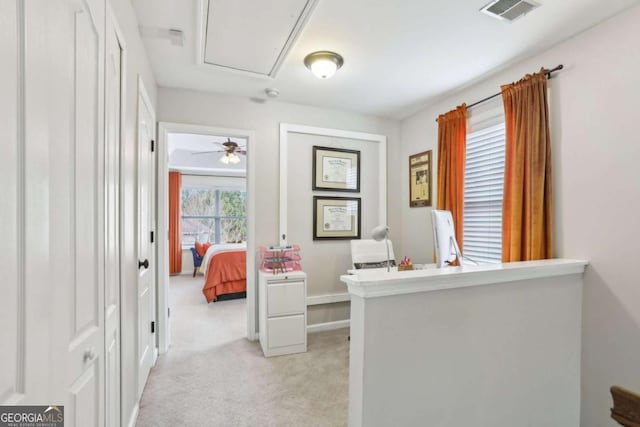 office area featuring visible vents, light colored carpet, attic access, and ceiling fan