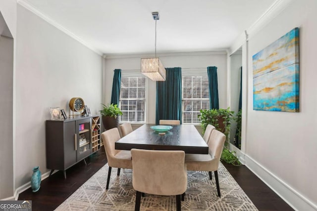 dining area featuring crown molding, baseboards, and wood finished floors