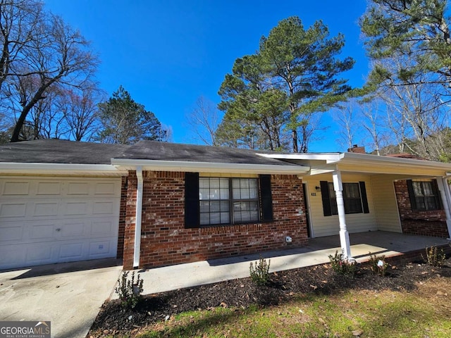 single story home featuring driveway, brick siding, and an attached garage