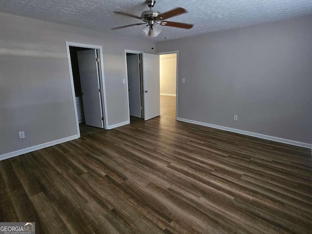 unfurnished bedroom with dark wood-type flooring, a ceiling fan, baseboards, and a textured ceiling