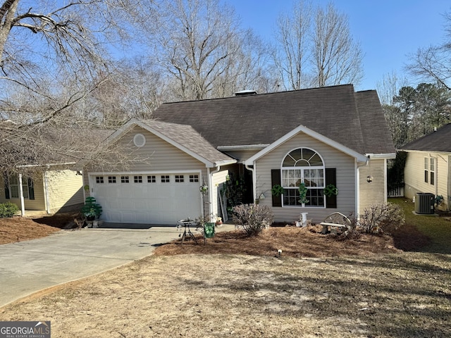 view of front of home featuring central AC unit, a garage, driveway, and a shingled roof