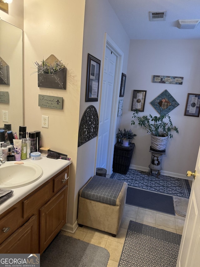 bathroom with tile patterned floors, visible vents, baseboards, and vanity