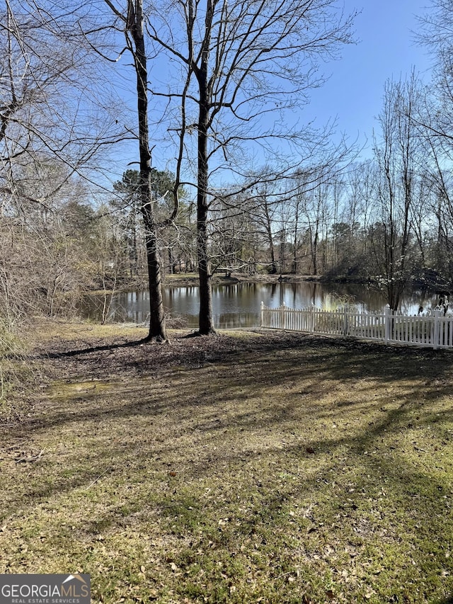 view of yard featuring fence and a water view