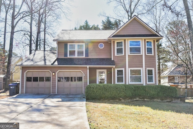 view of front of house with a front yard, concrete driveway, an attached garage, and fence