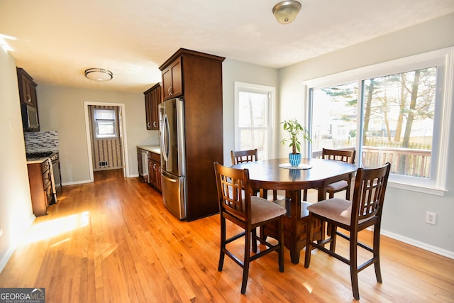 dining room with baseboards and light wood-style flooring