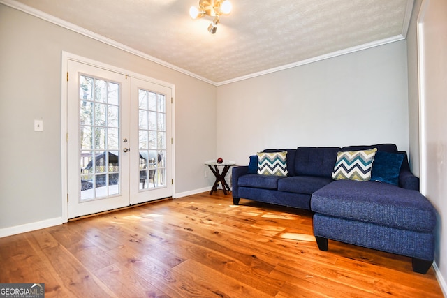 sitting room with wood finished floors, french doors, baseboards, and ornamental molding