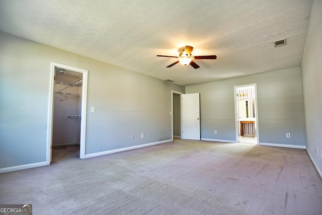 unfurnished bedroom featuring visible vents, carpet floors, baseboards, and a spacious closet