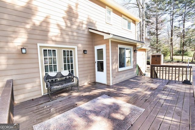 wooden terrace featuring an outbuilding and a shed