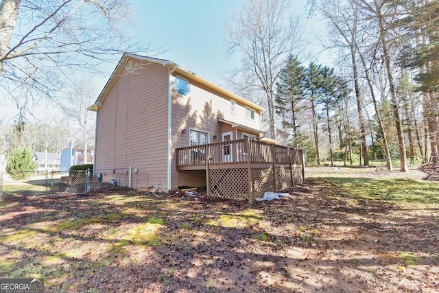 rear view of house with a deck and fence