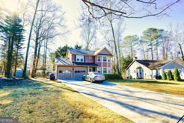 view of front of home with a garage, driveway, a front lawn, and fence