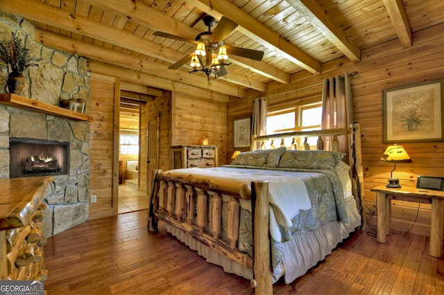 bedroom with beam ceiling, wood ceiling, wood walls, and hardwood / wood-style flooring