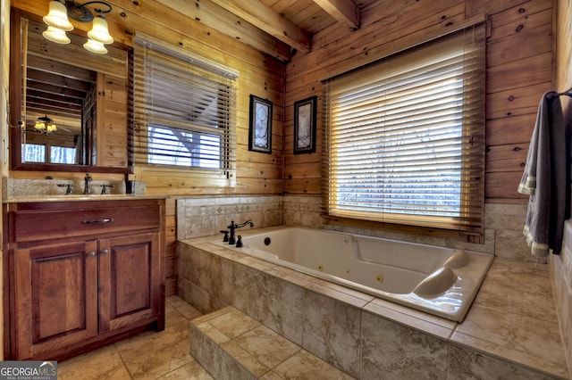 full bath with vanity, beam ceiling, a jetted tub, and wooden walls