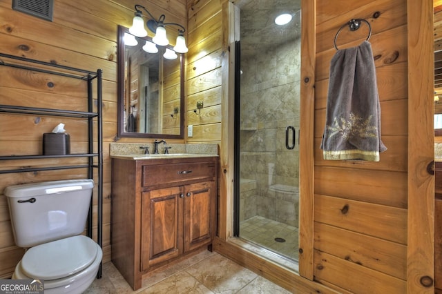 bathroom featuring visible vents, toilet, wood walls, a shower stall, and vanity