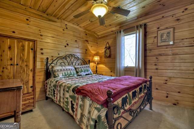 carpeted bedroom featuring ceiling fan, wood ceiling, and wood walls