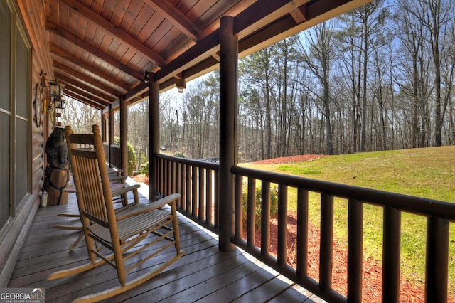 deck with a porch and a lawn