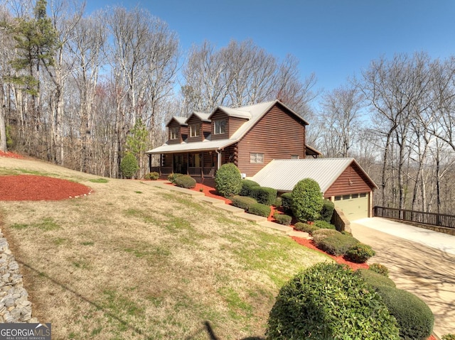 view of side of home with a porch, a yard, and driveway