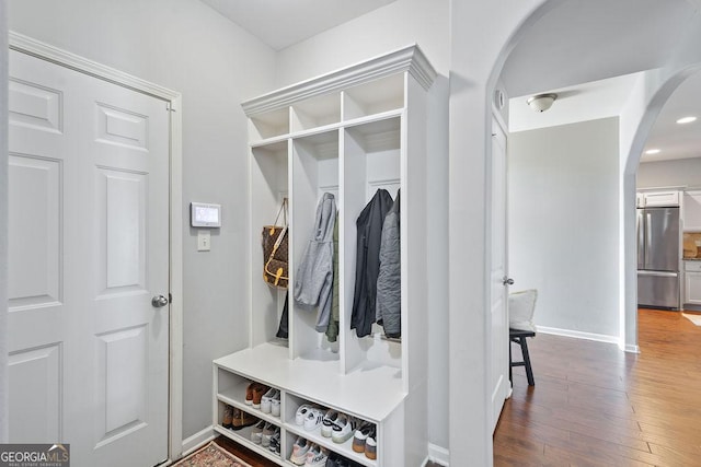 mudroom with hardwood / wood-style flooring, baseboards, and arched walkways