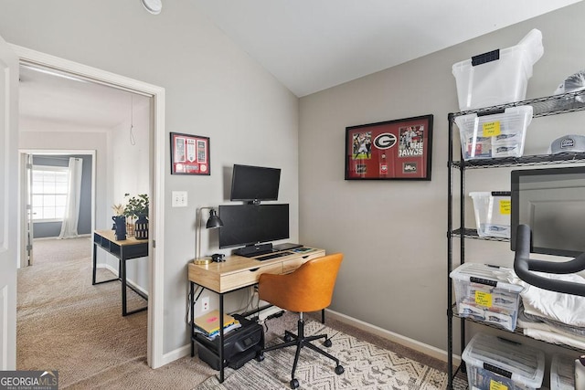 carpeted home office with baseboards and vaulted ceiling