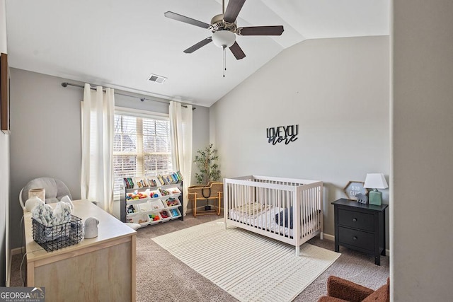 bedroom with a ceiling fan, visible vents, carpet floors, lofted ceiling, and a crib