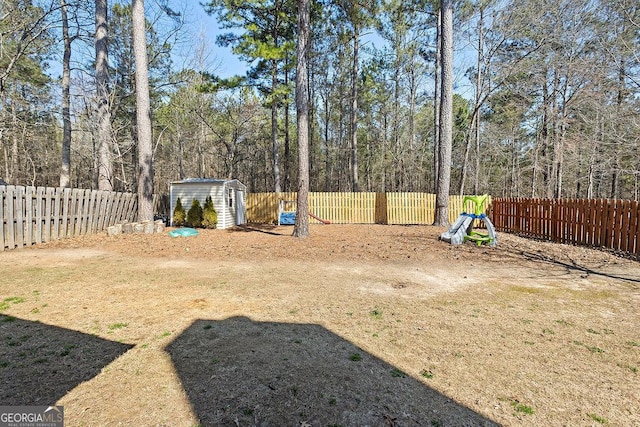 view of yard with a storage shed, an outdoor structure, and a fenced backyard