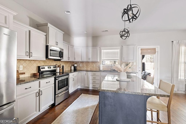 kitchen featuring dark wood-style floors, visible vents, appliances with stainless steel finishes, and a sink