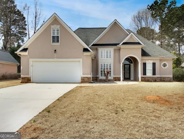 traditional-style house featuring french doors, stone siding, driveway, and stucco siding