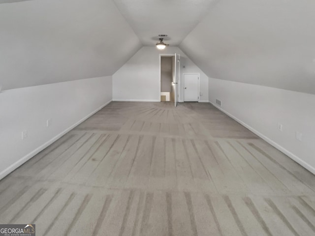 additional living space featuring visible vents, carpet floors, baseboards, and vaulted ceiling