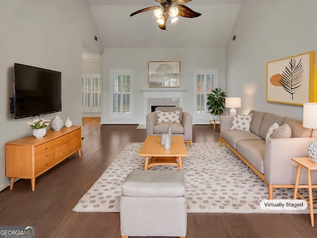 living area featuring a fireplace, wood finished floors, a ceiling fan, and high vaulted ceiling