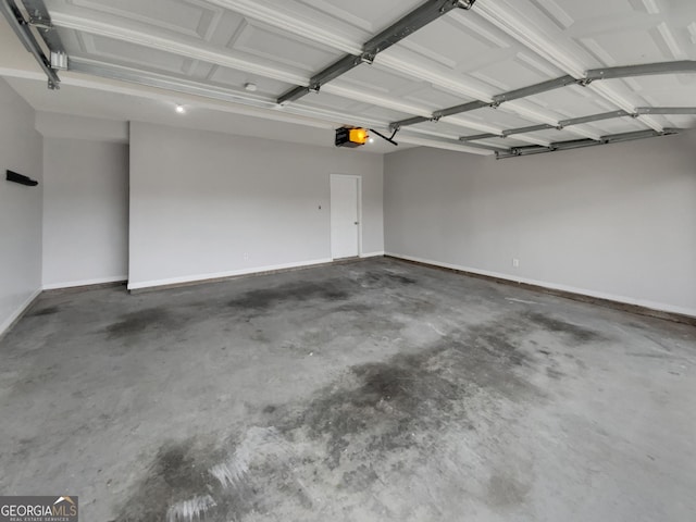 garage featuring a garage door opener and baseboards