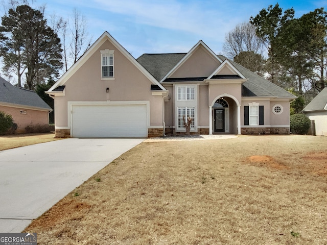 traditional home with driveway, stucco siding, a front lawn, french doors, and a garage