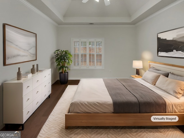 bedroom featuring visible vents, a tray ceiling, wood finished floors, crown molding, and vaulted ceiling