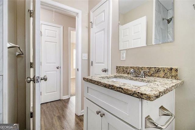 bathroom featuring baseboards, wood finished floors, and vanity