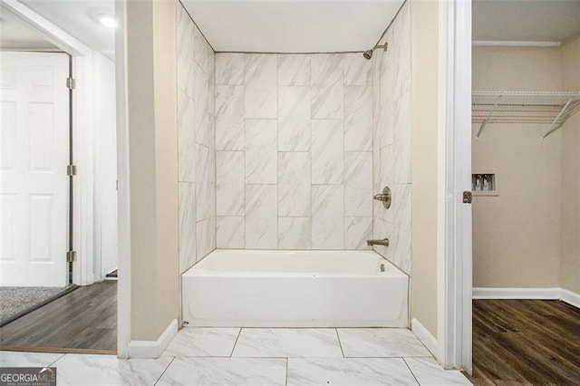 full bath with baseboards, marble finish floor, a spacious closet, and  shower combination