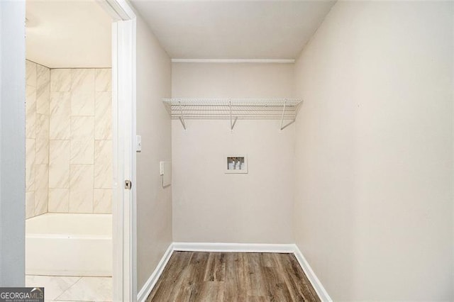 washroom featuring washer hookup, laundry area, wood finished floors, and baseboards