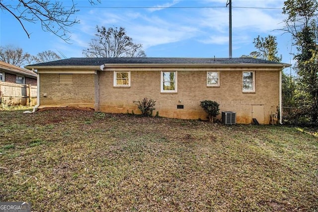 rear view of property featuring a yard, fence, and brick siding