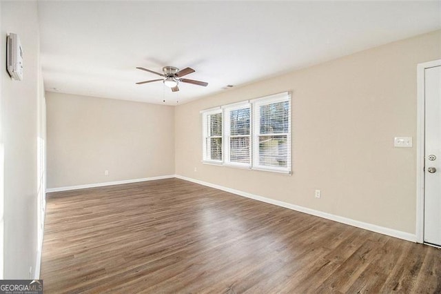 unfurnished room with baseboards, wood finished floors, and a ceiling fan