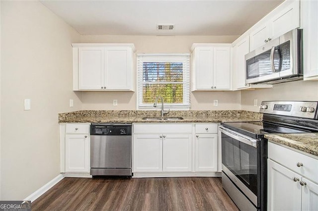 kitchen with visible vents, dark wood-type flooring, a sink, appliances with stainless steel finishes, and white cabinets