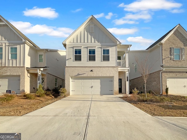 view of front of property with concrete driveway, an attached garage, brick siding, and board and batten siding