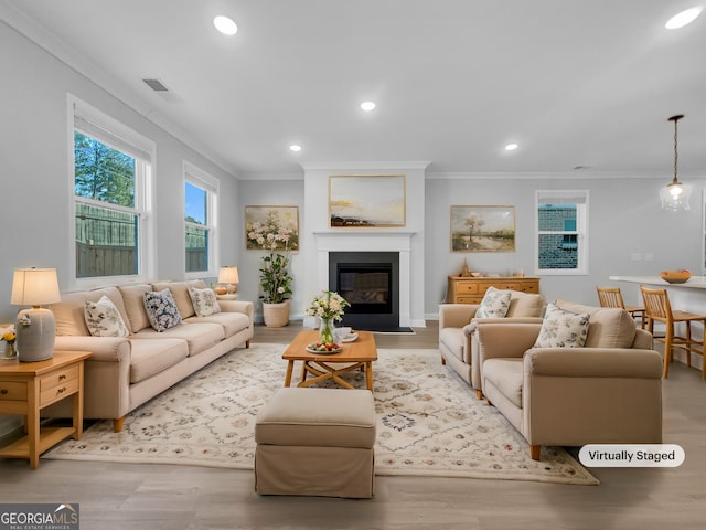 living room with recessed lighting, visible vents, wood finished floors, and crown molding