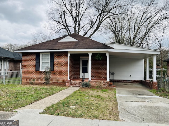 bungalow-style home with a front yard, fence, driveway, a carport, and crawl space