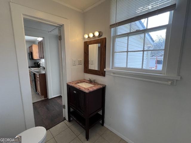 bathroom with vanity, baseboards, crown molding, toilet, and tile patterned floors