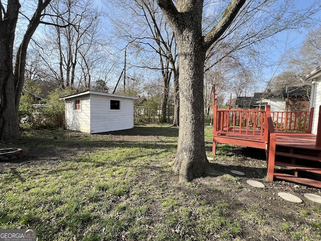 view of yard featuring a wooden deck, an outdoor structure, and a shed