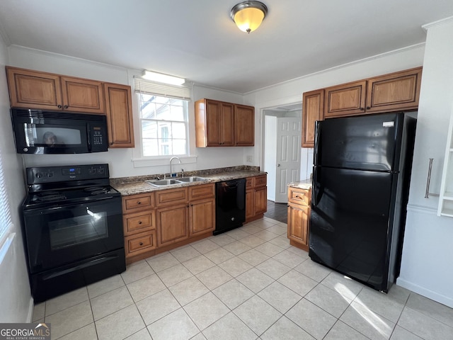 kitchen with brown cabinets, black appliances, ornamental molding, a sink, and light tile patterned flooring