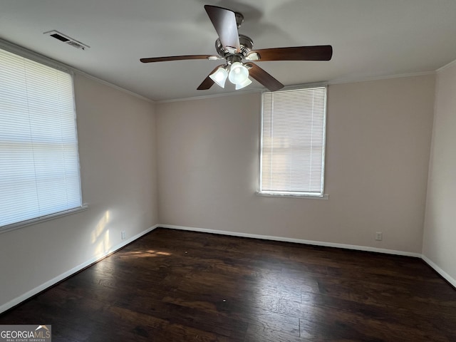 empty room featuring visible vents, crown molding, a ceiling fan, and wood finished floors