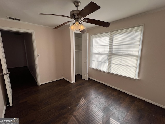 unfurnished bedroom featuring visible vents, baseboards, ornamental molding, and dark wood-style flooring