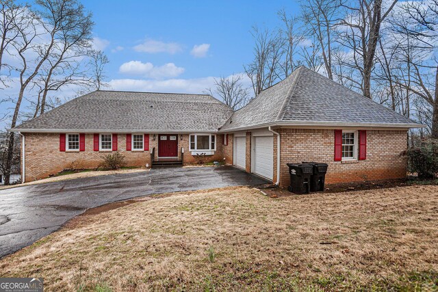 ranch-style house featuring an attached garage, brick siding, driveway, and a shingled roof