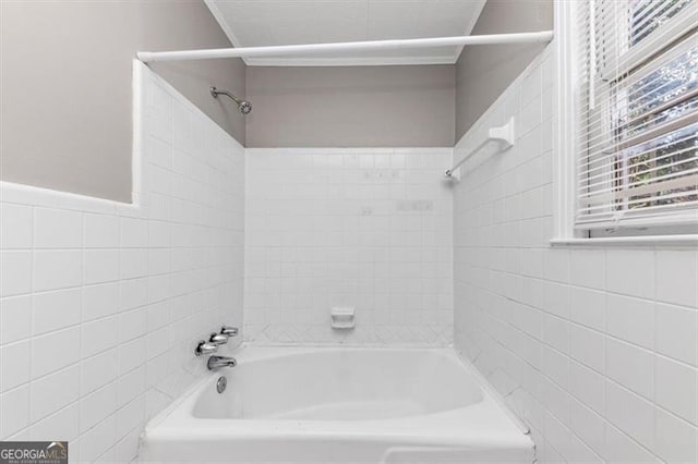 bathroom featuring tile walls and bathing tub / shower combination