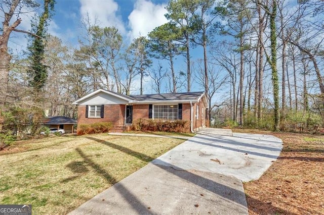 view of front of home featuring brick siding, a front lawn, and driveway