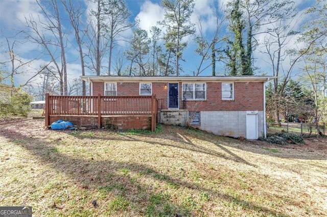 single story home featuring a deck, a front lawn, fence, and brick siding